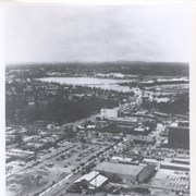 Aerial looking west from a position just east of First Avenue and just north of Wheeler Avenue.  Large white barn-like roof is San Gabriel Valley Lumber Co. building.  This later became the Sawmill Restaurant and in the early 1990's became Sports Rock Cafe. Directly opposite, is cleared land where Arcadia Public Library, Fire and Police were previously located.  Today there is a Medical Building on the site (65 N. First Avenue). Santa Anita Park and parking lot are seen in the distance.