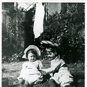 Baldwin M.Baldwin and Dextra Baldwin seated on grass, apparently at Baldwin Ranch.  Baldwin is younger on left.  Dextra has on large straw hat.