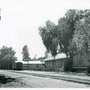 View from tracks toward Southern Pacific Freight Depot which was at 35 Santa Clara Street.  It is the low building closest to the camera.  There are two other warehouse type buildings seen beyond, also one box car sits on a siding.