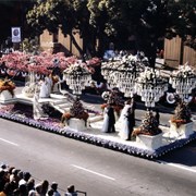 "The Senior Prom," Arcadia's float entry in the 1983 Pasadena Tournament of Roses Parade, features dancing couples on a ballroom floor beneath floral chandeliers.  The Arcadia Rose Court, with their escorts, are the dancers.
