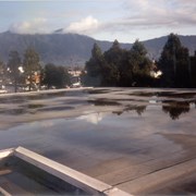 Water damage to the Arcadia Public Library resulting from rain.  This view is of standing water on the roof.  The San Gabriel Mountains are prominent in the background.
