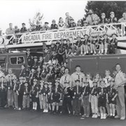 Large group of unidentified Arcadia Cub Scouts from Troop 111 shown in front of an Arcadia fire engine.  There are several adult leaders and Arcadia firefighters with the group.