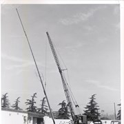 Construction in progress of the one-story Arcadia Police Department building at 250 W. Huntington Drive. Full view of crane putting up a tall structure, perhaps an antenna tower, which might be the same pillar-like structure seen in photo #1805.
