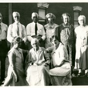 Photo of nine people sitting and standing in front of a home.  Man in back row, extreme left, is Oscar Seaquist, first druggist in Arcadia.