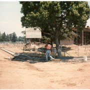 ID #1988-2011 show construction in progress for the Arcadia Community Center, at the site at Holly Avenue and Huntington Drive. Sign reads "Now under construction City of Arcadia Senior Citizens Center and Recreation Department Offices."