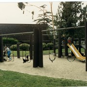 Unidentified park, showing children's play area, including a "bridge," slide, and swings.