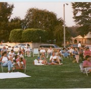 Arcadia Recreation Department summer concert at First Avenue School front lawn, shows a view of the audience seated on lawn chairs, The street in the background is First Avenue. Although the back of this photograph is stamped with its processing date of August 1997, "Summer Concert 1996" was handwritten on the envelope it came in from Arcadia Recreation Department.