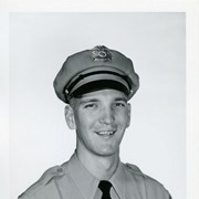 Portrait of Arcadia Police Officer Lloyd Burkholder, in uniform (hat, badge, necktie, patch).