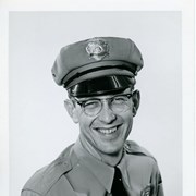 Portrait of Arcadia Police Officer Neal Johnson, in uniform (hat, badge, necktie, patch).