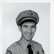 Portrait of Arcadia Police Department Officer Maynard Longway, in uniform, (hat, badge, necktie, patch).