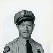 Portrait of Arcadia Police Department Officer Wayne G. Moore, in uniform, (hat, badge, necktie, patch).