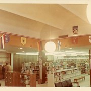 Children's Room, Arcadia Public Library, 20 W. Duarte Rd. decorated for Summer Reading Club with 1968 Summer Olympics theme, featuring flags and emblems of various nations. Shows interior furnishings and details such as card catalog, globe pendant lights, file cabinet, seating, shelving.