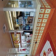 Interior view of order and pick up windows at Taco Lita restaurant located at 120 E. Duarte Road. Shows colorful orange, yellow and white tiles covering floor and counter base.