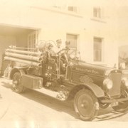 Chief Jim Nellis and A.A. Mussachia posing with Arcadia's first fire truck. Tires appear to be solid rubber. Location of this firehouse probably in part of City Hall facility at First and Huntington Drive.