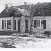 Front view of brick building, probably built as a home in 1930's, but used primarily as a business.  It is located at 22 E. Foothill Blvd, south side. There is a large (bare) jacaranda tree on right side of entrance in this photo.