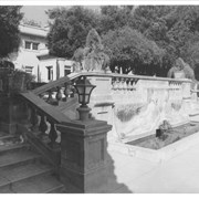 View of stairs up from drive to front entrance of Anoakia.  Decorative fountain and pond detail of cement balustrade along stair.  Front door is located in photo just above and to left of light fixture.