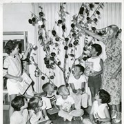 Marjorie Hickerson (later Phelps), Children's Librarian, with 8 youngsters receiving reading club awards from "Golden Tree."