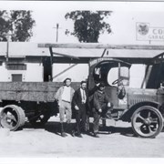 Corpe brothers garage and machine shop with truck parked in front of shop at 50 La Porte Street, Arcadia.  Standing by truck, left to right:  Enos Corpe, ?, Bill Cooper, mechanic, and Clint Corpe with hand on front of truck.  Truck has printed on it: Dairy Fertilizer, which was another business run by the Corpe brothers.