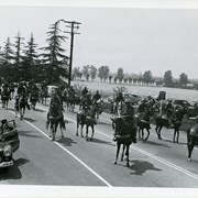 Mounted unit of about 31 men on Huntington Drive near Santa Anita Race Track Club House during parade for Peach Blossom Festival.