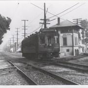 Single Pacific Electric Railway car (#1126) with destination card reading Monrovia-Glendora. Photographed on tracks in Arcadia at approximately First Avenue.  Pacific Electric control tower is to right of car.