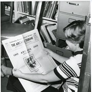 Carla Maggio shown sitting on floor by files in Arcadia Tribune office looking at an Arcadia Tribune dated 1933.  Ms. Maggio was employed by Arcadia Chamber of Commerce during 1978 and she wrote many articles on facets of Arcadia's Diamond Jublilee year.