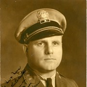 Studio portrait of Jack Richards in Arcadia Police uniform. Picture is inscribed across it.  Back of photo indicates he was chief from 1927-1939. Insignia on cap reads Chief.