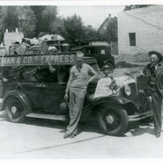 Young man with sweater and slacks (unidentified) and William Parker Lyon standing by sedan automobile piled high with what appears to be museum artifacts.  On hood of car is a sign reading: We are moving.  Auto license seems to bear date in 1930's,  Apparently this was at time Pony Express Museum was moved to Arcadia in 1935.