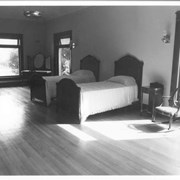 Looking east across Anita Baldwin's bedroom at Anoakia.  Twin beds, miscellaneous furniture, hardwood floors are seen.