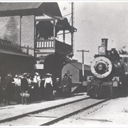 View east from track side of Santa Anita Railroad Station showing group of people waiting to board the Los Angeles bound train.  There are men, women and at least one child.