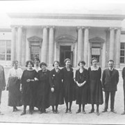 Group of eight women and three men standing at entrance of Arcadia Grammar School, which later became First Avenue Junior High School.  As identified in 1979 by Mr. Walters (82 year old former principal), left to right: 1. Reed Clark  4. Grace Benham  5. Martha Hoegee  6. Elvira McMillen  8. Elsie Anderson  9. Max Ireland  10. Elmer Neher.  Back row #11. Domenica Loyacano. Not identified: #2,3,7.