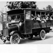 Chevrolet school bus with Arcadia City School printed on side.  There are about fourteen youngsters at the windows on one side.  Blond child sixth from left is C. Howard Olson.