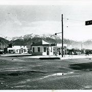 View of intersection of Baldwin Avenue and Duarte Road.  Service station on the NE corner was owned by Mr. Renshaw.  There is a two story house just north of station.  There has been a recent snow fall in the San Gabriel Mountains. Home to the north is F.E. Grote home.