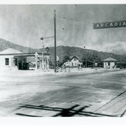 View of intersection of Baldwin and Duarte Road with Renshaw's service station on NE corner.  There is a real estate office in small square building further east on Duarte with a car parked in front.  There is a man standing near door into station.
