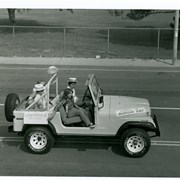 Jeep being driven in Diamond Jubilee Parade carrying James Helms, Chairman of Diamond Jubilee, and his wife.  Driver and other person in front seat not identified.
