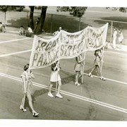 Young ladies carry banner reading:Arcadia-75th Birthday Parade Sept. 30 10:30 a.m.