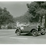Kay and Ruth Clifford (he was recent member of Arcadia School Board) are being driven in Diamond Jubilee Parade in what looks like old Ford convertible with a rumble seat.