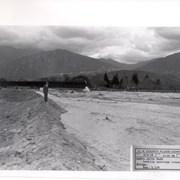 Looking directly north up flooded Santa Anita Wash.  Santa Fe Railroad Bridge can be seen upstream.  There is a man in a suit and hat standing at west edge of wash.  This was following heavy rains of early March 1938.