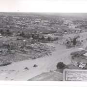 View NW up flooded Santa Anita Wash from above East bank below Duarte Road, probably the street seen crossing photo from right to left about half way down.  Nest crossing north with dark bridge, is Santa Fe Railroad tracks; next we believe to be for a pipeline; last clearly visible crossing is for Pacific Electric Railroad tracks.  Photo was taken following extreme flooding in 1938.