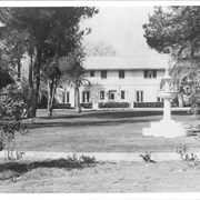 View south across lawn (with fountain in right foreground) toward 2 storied home of Erik Amalienborg or Prince Eric, brother of King of Denmark.  He built this home in late 1920s at 2607 S. Santa Anita Ave. and went into business raising chickens.  Building is now on grounds of Arcadia Congregational Church and is still (as of 1980) much as it is pictured here; it is used by the church for various purposes.