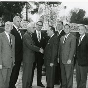 Gathering of eight dignitaries at time of dedication of fountains in NE corner of County Park.  Figure on left shaking hands is John Anson Ford, former County Supervisor.  He is shaking hand of Supervisor Frank Bonelli. Man in tweed coat to right of Bonelli is Norman Johnson, Director of Parks & Recreation Dept.  Man with dark-rimmed glasses seen behind two shaking hands is Arcadia City Manager Harold K. Shone.