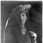 Portrait of Anita Baldwin. She is shown full face, wearing hat with long ribbon streaming from hat down her right shoulder.