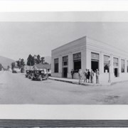 Looking north up First Avenue from corner with Huntington Drive. Six people standing in front of building on NE corner which is First National Bank or possibly had changed to Bank of Italy by this time. People L-R: First, not identified; next, Howard Bower, Bank Manager; next, not identified; Alberta Fabrick, escrow clerk; Jim Fletcher; Dick Hornie. Part of panorama, ID#s 916-921.
