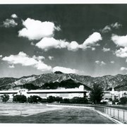 Panoramic view of Santa Anita Park taken from south parking area near water drainage course that formerly cut across property.  View is looking north toward the mountains and includes everything from the club house(on the right) to the far west end of the grandstand.  It is a crystal clear day.